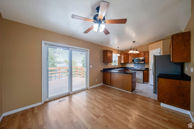 4213 S 2850 W, Roy, UT 84067 - kitchen with stainless steel microwave, a peninsula, brown cabinets, light wood-style flooring, and white range oven