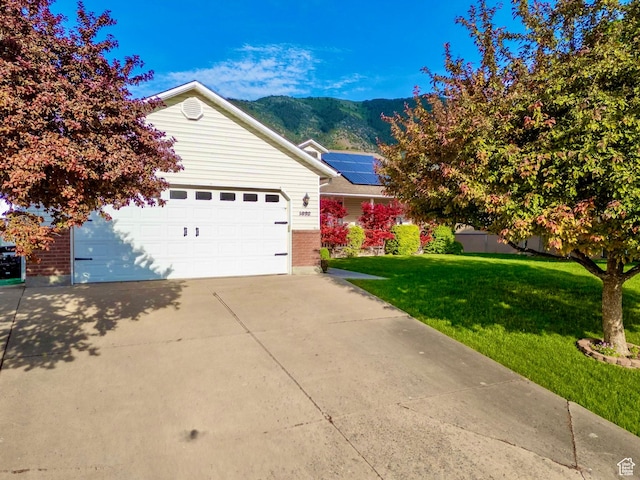 1092 S 470 E, Providence, UT 84332 - view of front of house with a mountain view, brick siding, a front lawn, driveway, and an attached garage