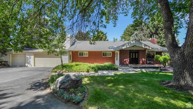 412 S 100 E, Salem, UT 84653 - ranch-style home featuring asphalt driveway, an attached garage, a front lawn, brick siding, and a chimney