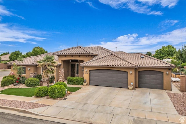 4034 Fortune Way, Washington, UT 84780 - mediterranean / spanish-style house featuring stucco siding, an attached garage, concrete driveway, and a tiled roof
