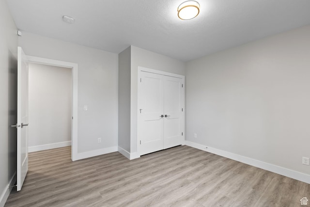 915 E 2100 N, North Ogden, UT 84414 - unfurnished bedroom featuring light wood-style floors, a closet, and baseboards