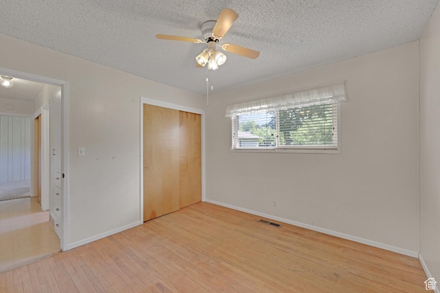 2458 N 575 E, North Ogden, UT 84414 - unfurnished bedroom with baseboards, light wood-style flooring, a closet, a textured ceiling, and a ceiling fan
