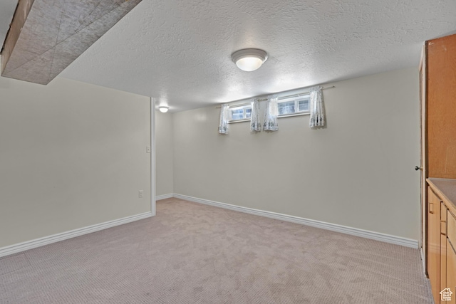 2458 N 575 E, North Ogden, UT 84414 - below grade area featuring light carpet, baseboards, and a textured ceiling