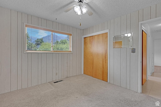 2458 N 575 E, North Ogden, UT 84414 - unfurnished bedroom featuring a textured ceiling, carpet, wooden walls, and ceiling fan