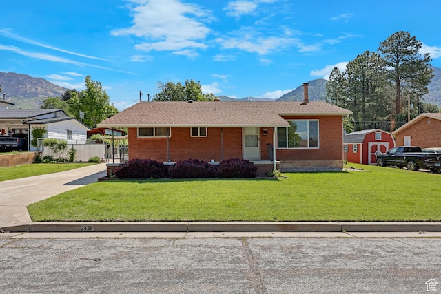 2458 N 575 E, North Ogden, UT 84414 - view of front facade with brick siding, a front yard, a mountain view, and concrete driveway