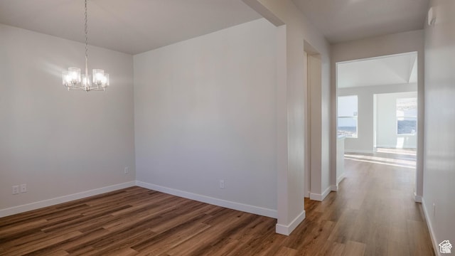 877 W Sika Cir S Unit 203, Saratoga Springs, UT 84045 - spare room featuring dark wood-type flooring, a chandelier, and baseboards