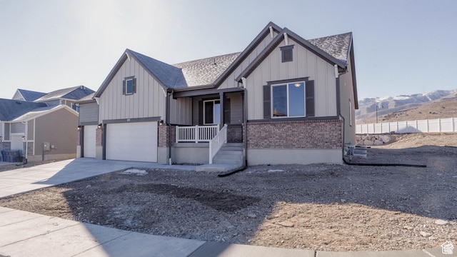 877 W Sika Cir S Unit 203, Saratoga Springs, UT 84045 - view of front facade featuring board and batten siding, driveway, a garage, brick siding, and covered porch