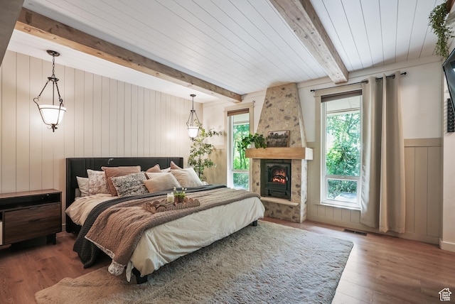 153 W 4350 N, Pleasant View, UT 84414 - bedroom featuring beam ceiling, wood finished floors, a stone fireplace, wood walls, and a wainscoted wall