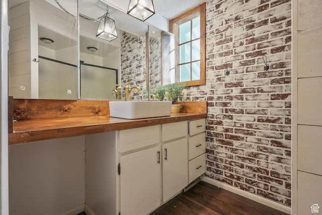153 W 4350 N, Pleasant View, UT 84414 - full bath with wood finished floors, vanity, a shower with door, baseboards, and brick wall