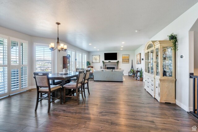 15058 S Spring Canyon Dr, Herriman, UT 84096 - dining room featuring dark wood finished floors, a chandelier, a fireplace, recessed lighting, and baseboards