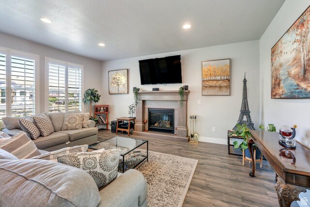 15058 S Spring Canyon Dr, Herriman, UT 84096 - living room with wood finished floors, recessed lighting, baseboards, and a glass covered fireplace