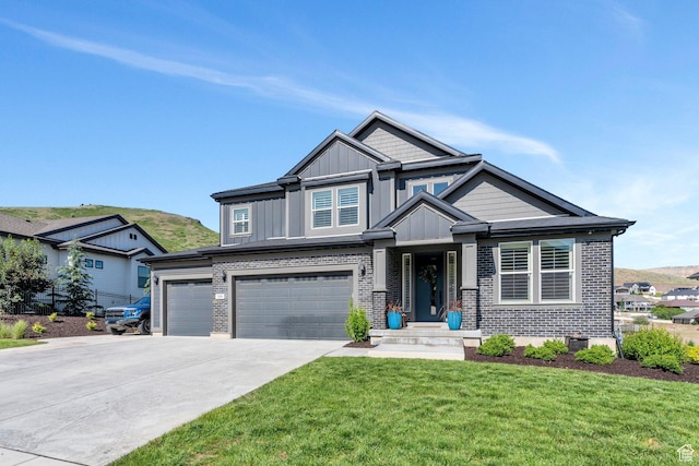 15058 S Spring Canyon Dr, Herriman, UT 84096 - craftsman inspired home with a front lawn, board and batten siding, driveway, an attached garage, and brick siding