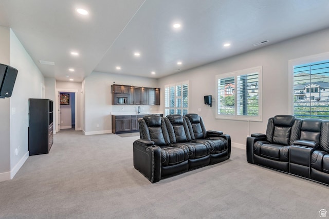 15058 S Spring Canyon Dr, Herriman, UT 84096 - living area featuring light colored carpet, baseboards, plenty of natural light, recessed lighting, and bar with sink