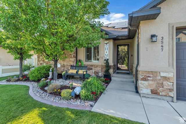 3547 E Jacobs Way, Eagle Mountain, UT 84005 - entrance to property featuring roof mounted solar panels, stucco siding, stone siding, roof with shingles, and a yard
