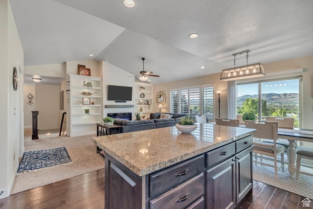 3547 E Jacobs Way, Eagle Mountain, UT 84005 - kitchen featuring lofted ceiling, ceiling fan, dark wood-style flooring, light stone countertops, and a kitchen island