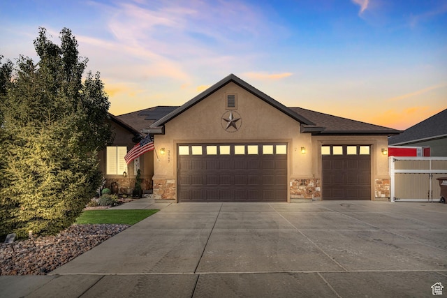 3547 E Jacobs Way, Eagle Mountain, UT 84005 - view of front of home featuring stone siding, a garage, driveway, and stucco siding