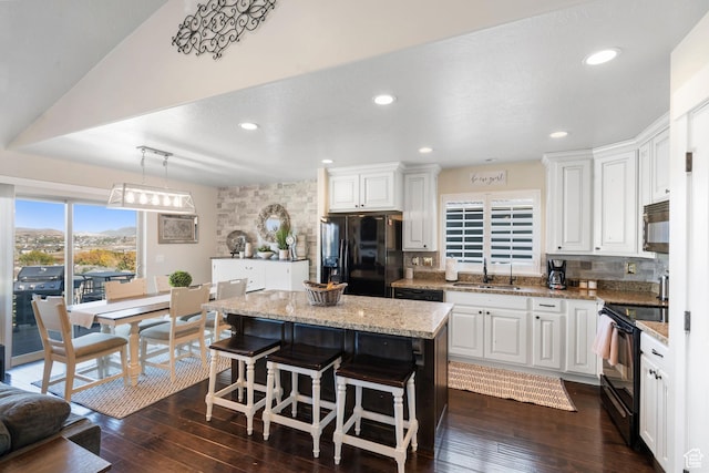 3547 E Jacobs Way, Eagle Mountain, UT 84005 - kitchen with black appliances, decorative backsplash, a center island, white cabinets, and recessed lighting