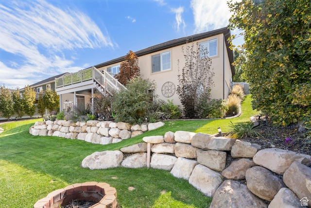 3547 E Jacobs Way, Eagle Mountain, UT 84005 - back of property with an outdoor fire pit, stairway, a wooden deck, and a yard