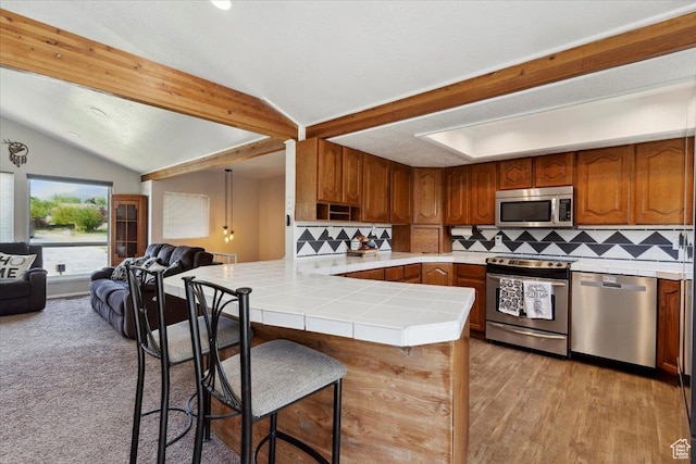 1602 E 2550 N, Layton, UT 84040 - kitchen with stainless steel appliances, tile countertops, open floor plan, a peninsula, and tasteful backsplash