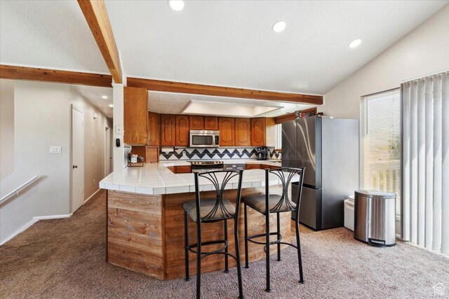 1602 E 2550 N, Layton, UT 84040 - kitchen with stainless steel appliances, a peninsula, light colored carpet, brown cabinetry, and tasteful backsplash
