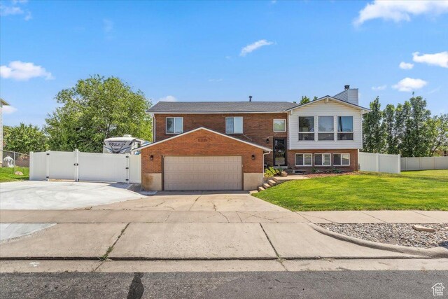 1602 E 2550 N, Layton, UT 84040 - view of front of house with brick siding, a gate, a garage, and a chimney