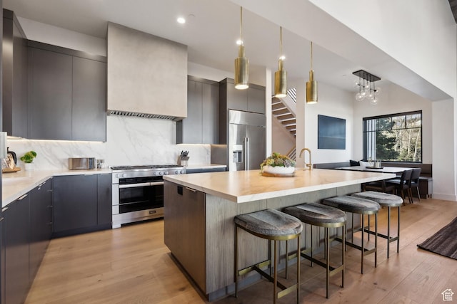 8200 E Royal St Unit 50, Deer Valley, UT 84060 - kitchen with premium appliances, modern cabinets, a kitchen bar, decorative backsplash, and light wood finished floors