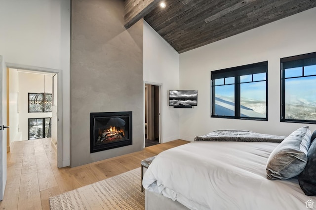 8200 E Royal St Unit 50, Deer Valley, UT 84060 - bedroom with high vaulted ceiling, a glass covered fireplace, multiple windows, light wood-style flooring, and baseboards