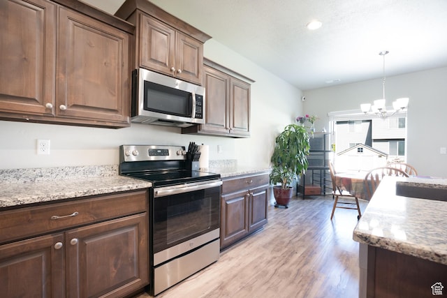 2534 S 2200 W, West Haven, UT 84401 - kitchen with stainless steel appliances, a chandelier, light wood finished floors, a sink, and pendant lighting
