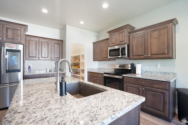 2534 S 2200 W, West Haven, UT 84401 - kitchen with stainless steel appliances, light wood-style floors, a sink, light stone counters, and recessed lighting