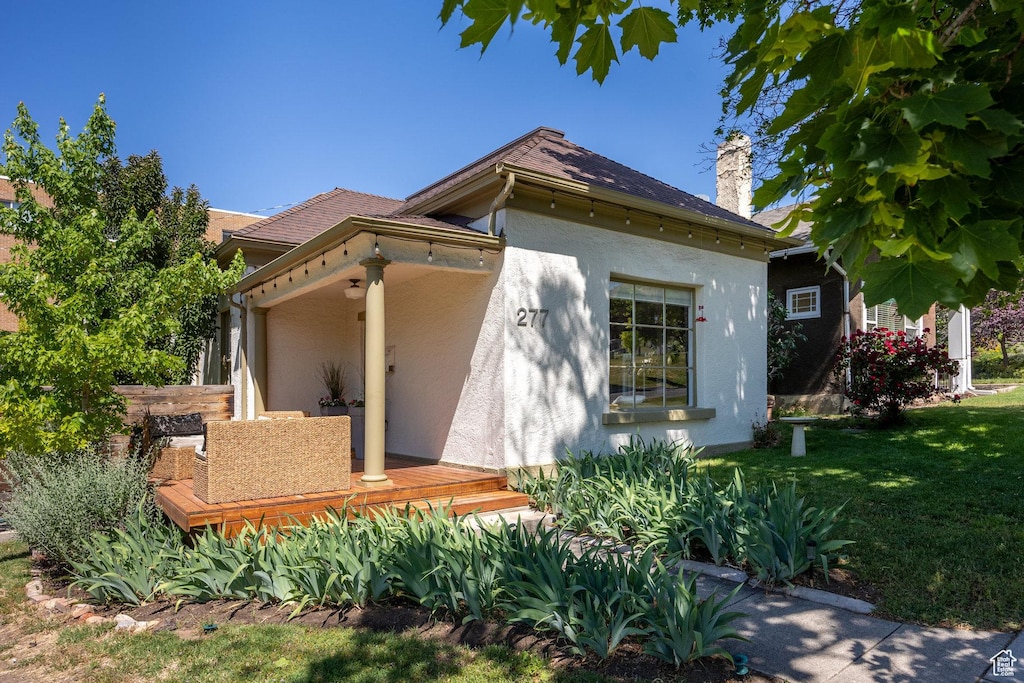 277 N N St E, Salt Lake City, UT 84103 - view of property exterior with stucco siding, a chimney, and a yard