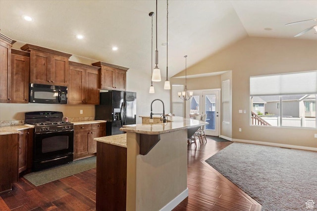 2432 Field Stone Way, Layton, UT 84041 - kitchen featuring black appliances, vaulted ceiling, brown cabinetry, a center island with sink, and decorative light fixtures