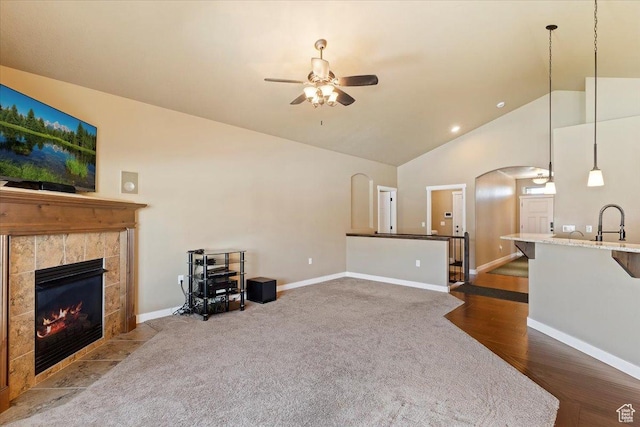 2432 Field Stone Way, Layton, UT 84041 - living room featuring a ceiling fan, arched walkways, a tile fireplace, dark colored carpet, and baseboards