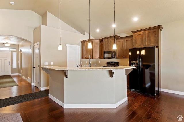 2432 Field Stone Way, Layton, UT 84041 - kitchen with black appliances, brown cabinetry, a breakfast bar area, dark wood-type flooring, and arched walkways