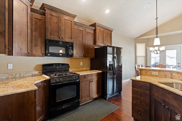 2432 Field Stone Way, Layton, UT 84041 - kitchen featuring black appliances, lofted ceiling, dark wood-style floors, decorative light fixtures, and light stone counters