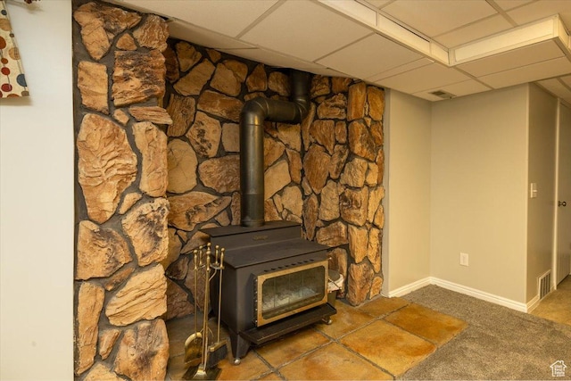 6837 S Baldwin Ave, West Jordan, UT 84084 - detailed view of carpet floors, a wood stove, baseboards, and a paneled ceiling