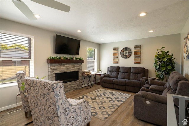 6837 S Baldwin Ave, West Jordan, UT 84084 - living area featuring wood finished floors, recessed lighting, a stone fireplace, and baseboards