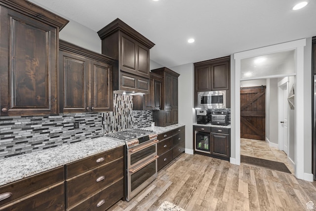 2609 W 3075 S, West Haven, UT 84401 - kitchen featuring appliances with stainless steel finishes, dark brown cabinets, baseboards, decorative backsplash, and light wood-style floors