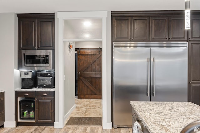 2609 W 3075 S, West Haven, UT 84401 - kitchen with built in appliances, dark brown cabinets, light wood-style floors, baseboards, and light stone countertops