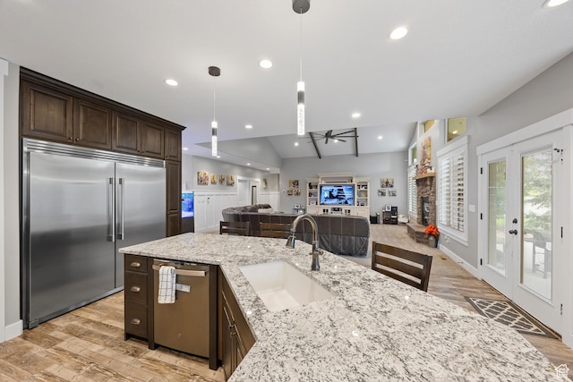 2609 W 3075 S, West Haven, UT 84401 - kitchen featuring stainless steel appliances, a sink, a ceiling fan, a fireplace, and dark brown cabinetry