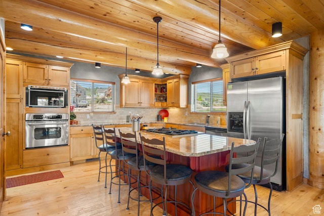 125 W Persimmon Dr Unit 2, Garden City, UT 84028 - kitchen with appliances with stainless steel finishes, light wood finished floors, light stone counters, tasteful backsplash, and a kitchen bar