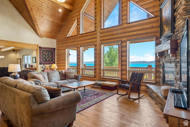 125 W Persimmon Dr Unit 2, Garden City, UT 84028 - living room with high vaulted ceiling, log walls, wood ceiling, a stone fireplace, and light wood-style floors