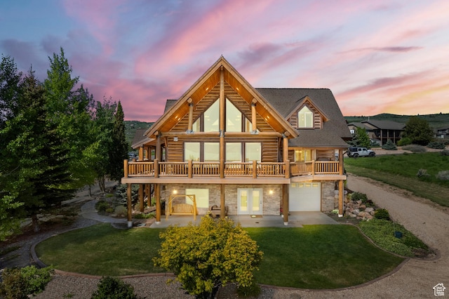 125 W Persimmon Dr Unit 2, Garden City, UT 84028 - back of property at dusk featuring stone siding, a lawn, log exterior, and a wooden deck