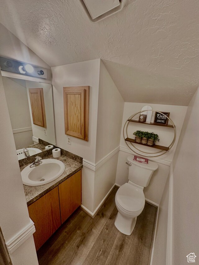 1175 S Canyon Rd E Unit 81, Ogden, UT 84404 - half bath featuring a textured ceiling, wood finished floors, vaulted ceiling, toilet, and vanity
