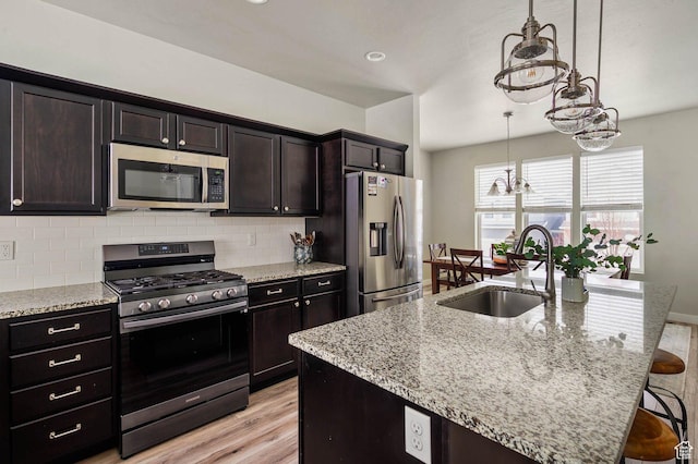 5128 W Stockfield Ln N, Herriman, UT 84096 - kitchen with appliances with stainless steel finishes, a sink, a chandelier, tasteful backsplash, and light wood-style flooring