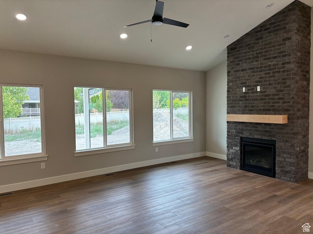 3323 N 1200 W, Pleasant View, UT 84414 - unfurnished living room featuring plenty of natural light, wood finished floors, ceiling fan, a fireplace, and vaulted ceiling
