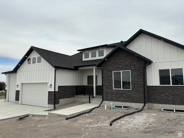 3323 N 1200 W, Pleasant View, UT 84414 - view of front facade featuring board and batten siding, driveway, an attached garage, and a shingled roof