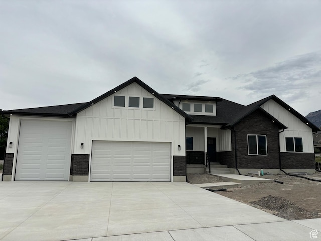 3323 N 1200 W, Pleasant View, UT 84414 - view of front of property with a garage, driveway, board and batten siding, and brick siding