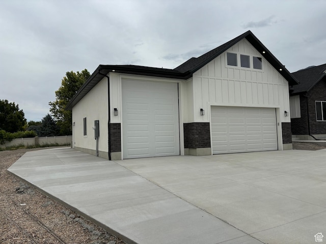 3323 N 1200 W, Pleasant View, UT 84414 - view of front of property with board and batten siding, concrete driveway, a garage, and brick siding