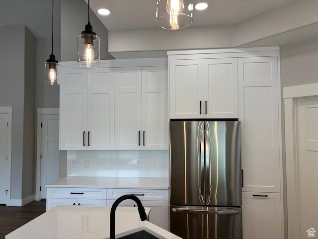 3323 N 1200 W, Pleasant View, UT 84414 - kitchen featuring freestanding refrigerator, white cabinets, dark wood-type flooring, decorative light fixtures, and light stone counters