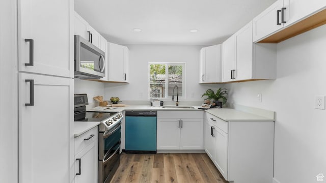 72 W Leadville Row, Eureka, UT 84628 - kitchen featuring appliances with stainless steel finishes, a sink, light wood-style flooring, white cabinets, and recessed lighting